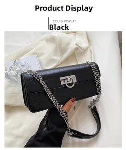 Detail of black crocodile texture faux leather bag with silver metal lock and chain strap