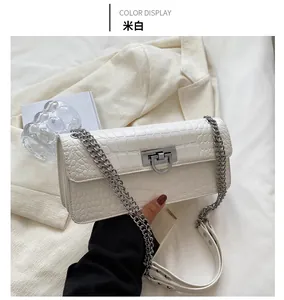 Detail of off-white crocodile texture bag with silver U-shaped lock and chain strap