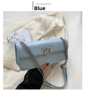 Detail of light blue croc-effect shoulder bag with silver metal clasp and chain strap