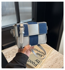 Detail of silver metallic leather and blue denim woven checkerboard crossbody bag strap