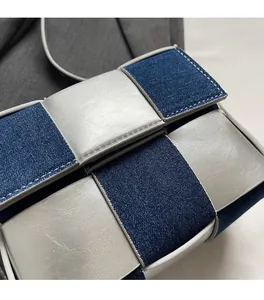 Detail of woven crossbody bag showing denim and silver leather texture with checkers