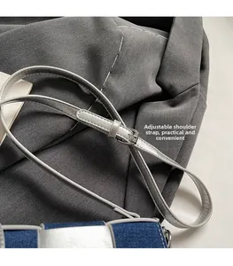 Close-up of adjustable silver leather strap and blue denim patchwork on a crossbody bag