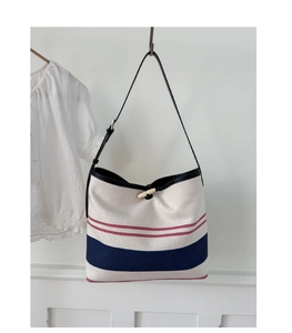 Detail of striped woven beach tote with nautic lines and horn buckle closure
