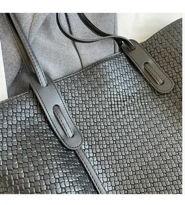 Detailed close-up of black woven PU leather tote bag with premium texture and handle