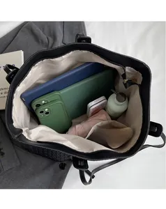 Spacious interior of black woven tote bag showing storage for tablet and essentials