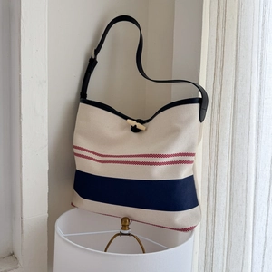 Striped canvas tote bag with nautical blue and red accents and adjustable strap