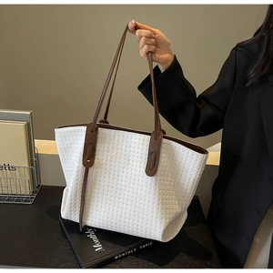 Detail of woven texture and brown leather strap on white tote bag for women