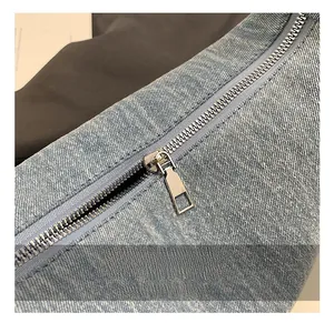 Detail of silver metal zipper and high-quality light blue washed denim fabric texture