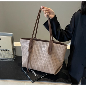 Detail of the high-capacity woven tote bag with premium brown leather handles