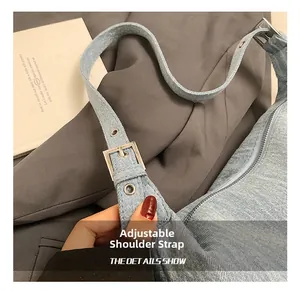 Detail show of light blue denim bag featuring adjustable strap and silver metal hardware