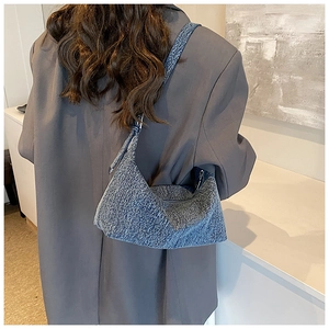 Modern grey-blue denim hobo bag shown on model, stylish crescent shoulder bag for women