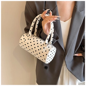 Chic cylindrical PU leather shoulder bag featuring black polka dots on white background