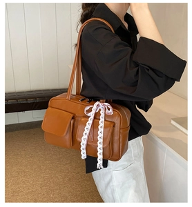 Close-up of brown vintage bowling bag with lace bow detail and side pocket