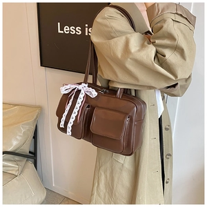 Detailed view of brown retro PU leather tote bag with elegant white lace bow decoration