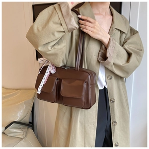 Brown vintage faux leather tote bag detail with double front pockets and lace bow charm