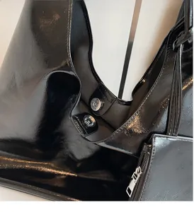 Detail of glossy black patent leather surface with silver magnetic clasps and zipper