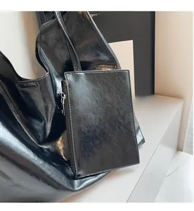 Detail of high-gloss black PU leather hobo bag with matching rectangle zipper coin pouch