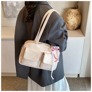Detail of cream white faux leather tote bag with lace bow and front flap pockets