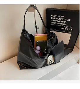 Internal spacious capacity of black patent leather tote bag showing items like a tablet