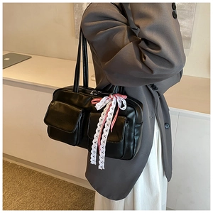 Detail of black bowling bag with lace trim and red checkered bow charm on pockets