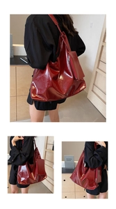 Detail of dark red glossy patent leather tote bag with matching hanging charm pouch