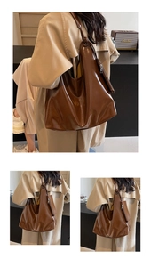 Detail of dark brown glossy large shoulder bag with matching mini coin purse charm
