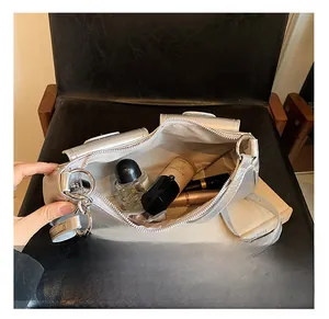Detailed interior of silver handbag showing spacious storage with cosmetics and zipper