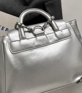 Détails de couture sur cuir synthétique argenté et chaîne métallique pour ce sac chic