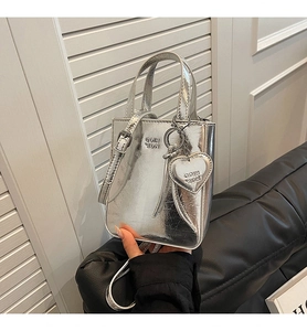 Détail du sac cabas argenté métallisé avec pendentif cœur et bandoulière