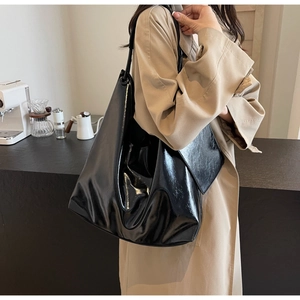 Glossy black large capacity tote bag shown on shoulder for daily commuting style