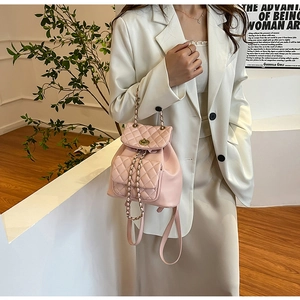 Détail du sac à dos matelassé rose avec fermoir doré et bandoulière en chaîne