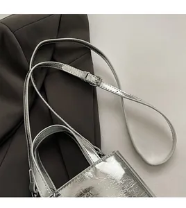 Détail de la texture argentée du sac à main avec sa bandoulière réglable et ses finitions