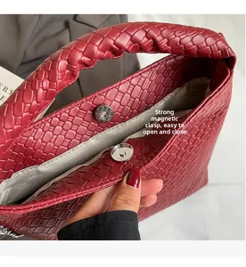 Détail du sac tressé rouge montrant le fermoir magnétique et la doublure en sergé