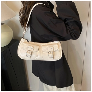 Detail of off-white glossy faux leather shoulder bag with silver horseshoe buckles