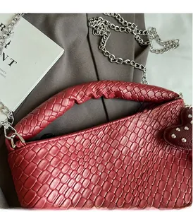 Détails du sac cabas bordeaux tressé avec chaîne argentée et breloque coeur
