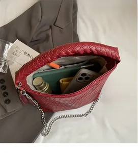 Vue intérieure d'un sac seau tressé rouge foncé spacieux avec une chaîne argentée