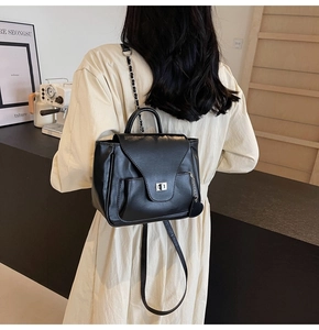 Détail du sac à dos convertible en cuir noir avec chaîne et breloque coeur