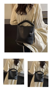 Détail de la texture tressée noire sur sac seau avec rivet en cœur et bandoulière