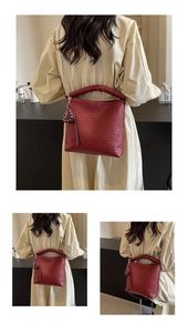 Détail du sac seau rouge tressé avec breloque cœur et bandoulière en chaîne