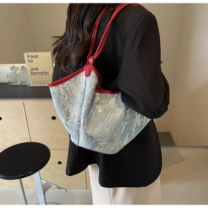 Detail der großen Shopper-Tasche aus hellblauen Pailletten mit roten Lederriemen