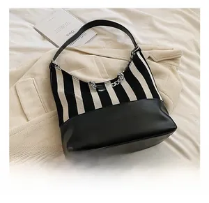 Detail shot of a black and white striped hobo bag with a chunky silver metal chain link