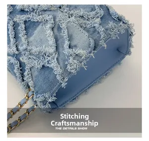 Gros plan sur la texture denim avec surpiqûres effilochées et chaîne en métal doré