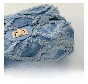 Gros plan sur le tissu denim matelassé avec bords effilochés et fermoir doré rotatif