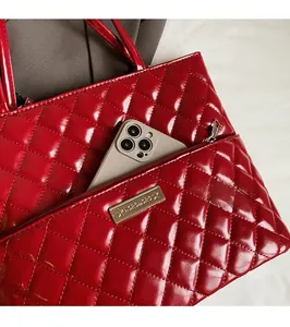Detail of red quilted faux leather handbag showing functional front zipper pocket