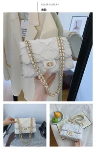 Détail du sac en denim matelassé blanc cassé avec chaîne dorée et texture à franges