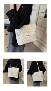 Detailed view of white quilted tote bag with glossy finish and silver metal logo plate