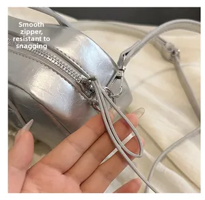 Detail showing smooth silver metal zipper on a metallic pleated small square bag