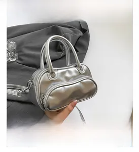 Detail view of silver Y2K handbag with dual handles and shiny metallic PU leather finish