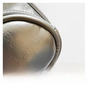 Detail shot of the metallic silver textured fabric and premium zipper on the crossbody bag