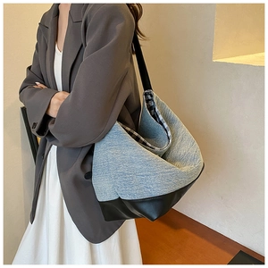 Detail of blue denim and black leather tote bag with stylish checkered lining interior